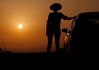 Image showing Silhouette woman with hat standing near car