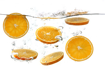 Image showing Oranges Falling Into Splashing Clear Water
