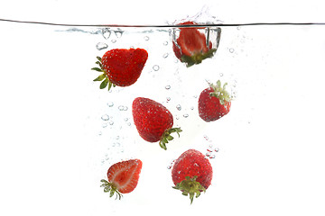 Image showing Strawberries Falling Into Splashing Clear Water