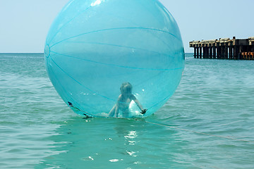 Image showing Little girl inside a giant balloon on the sea surface