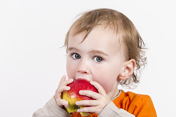 Image showing young child eating red apple