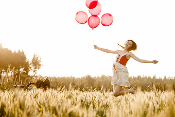 Image showing Girl jumping with balloons