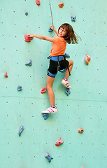 Image showing smiling child climbing up the wall