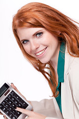 Image showing attractive smiling redhead business woman with calculator isolated