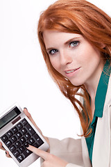 Image showing attractive smiling redhead business woman with calculator isolated