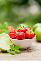 Image showing fresh tasty sweet strawberries and green lime outdoor in summer