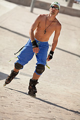 Image showing young man with inline skates in summer outdoor 