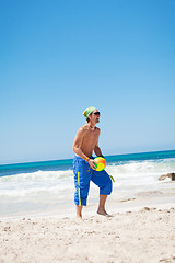 Image showing attractive young man playing volleyball on the beach