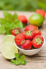 Image showing fresh tasty sweet strawberries and green lime outdoor in summer