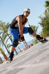 Image showing young man with inline skates in summer outdoor 