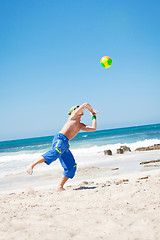 Image showing attractive young man playing volleyball on the beach