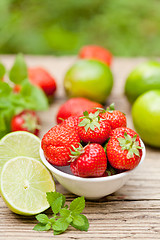 Image showing fresh tasty sweet strawberries and green lime outdoor in summer