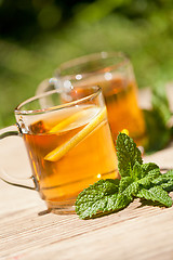 Image showing fresh tasty hot tea lemon and mint outdoor in summer 