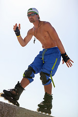 Image showing young man with inline skates in summer outdoor 