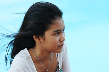 Image showing Happy girl relaxing by the swimming pool