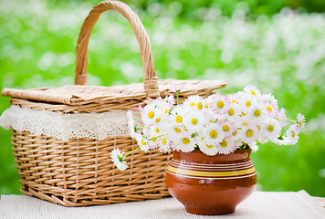 Image showing A bouquet of daisies in a pot on the table for a picnic  