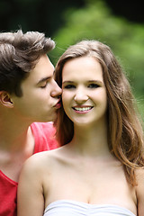 Image showing Teenage boy kissing his pretty girlfriend