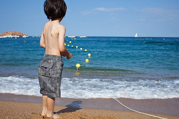 Image showing boy looking at the blue sea