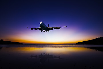 Image showing Airplane flying on colorful evening sky over sea at sunset with 