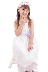 Image showing little girl wearing white dress and posing on chair on white bac