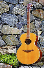 Image showing Classic guitar backed to wall 