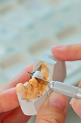 Image showing hand of technician in a dental laboratory manufacturing 