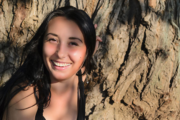 Image showing The girl near a tree trunk