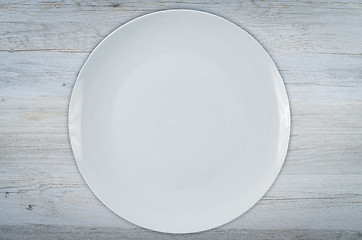 Image showing Empty white plate on wooden table 