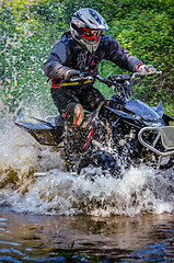 Image showing Quad rider through water stream