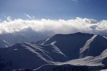 Image showing Winter mountains in evening and paragliders