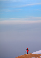 Image showing Hiker on edge of cliff in sunrise