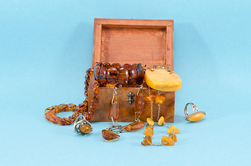 Image showing amber stone jewelry retro wooden box on blue 