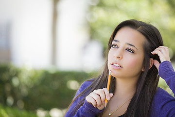 Image showing Pensive Mixed Race Female Student with Pencil on Campus