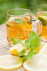 Image showing fresh tasty hot tea lemon and mint outdoor in summer 