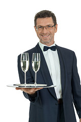 Image showing adult male waiter serving two glass of champagne isolated