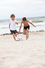 Image showing happy family father two kids playing football on beach summer 