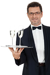 Image showing adult male waiter serving two glass of champagne isolated