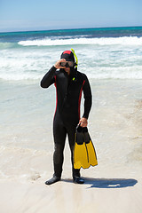 Image showing male diver with diving suit snorkel mask fins on the beach