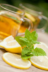 Image showing fresh tasty hot tea lemon and mint outdoor in summer 