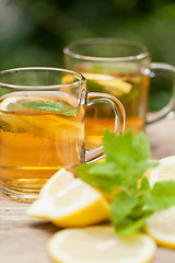 Image showing fresh tasty hot tea lemon and mint outdoor in summer 