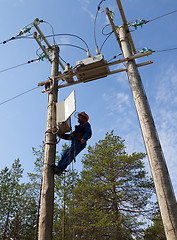 Image showing Electrician to service the control of reclosers on voltage poles