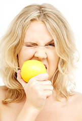 Image showing lovely blond biting lemon