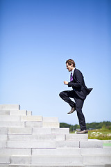 Image showing Businessman running up stairs