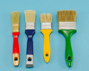 Image showing hand paint brush color different size on blue 