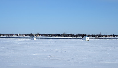 Image showing Ice fishing huts on a frozen river