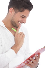 Image showing Man smiling as he reads notes on a clipboard