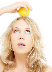 Image showing healthy blond holding lemon on her head