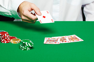 Image showing player's hand throws a playing card