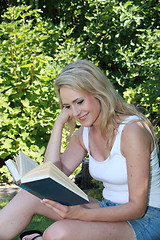 Image showing Young woman reading in the garden