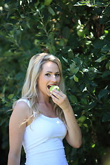 Image showing Young woman eating a green apple